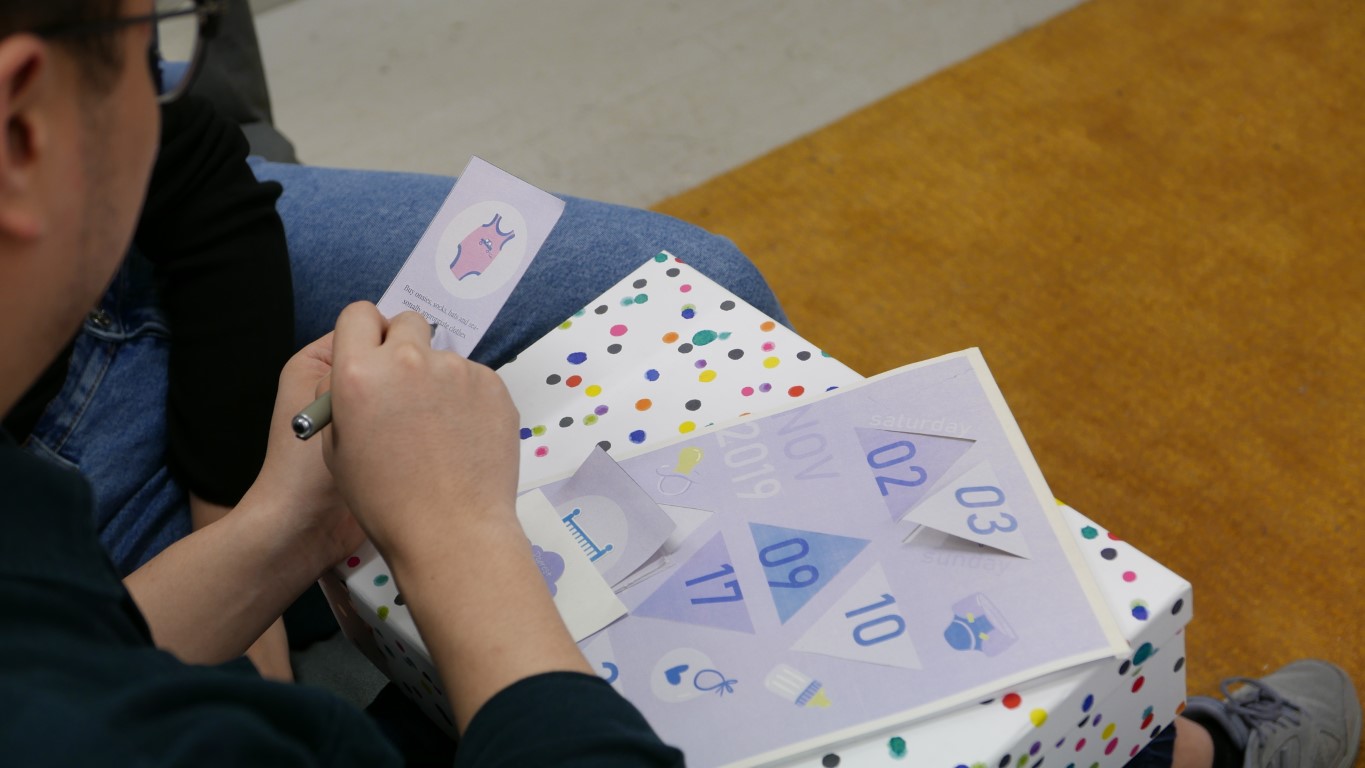 A man holds a card pointing at a topic on the card