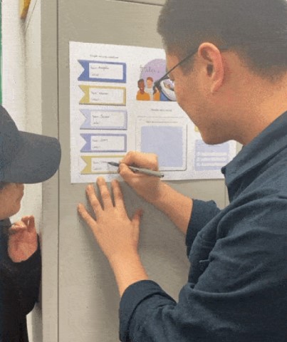 A man writes names and phone numbers on a sheet.